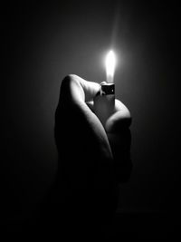 Close-up of hand holding illuminated cigarette lighter
