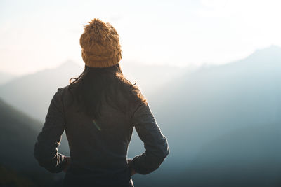 Rear view of woman standing against sky