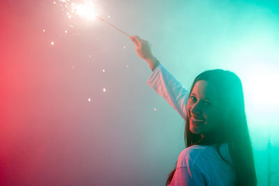 Portrait of woman holding illuminated sparkler