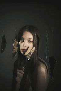 Portrait of a young woman looking away against wall