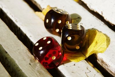 High angle view of dices and leaves on wooden bench