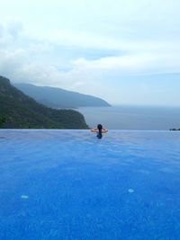 Man in swimming pool against sky