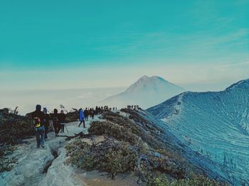 People on mountain against sky