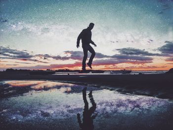 Silhouette man levitating over sea against sky during sunset