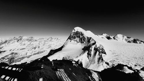 Scenic view of snowcapped mountains against clear sky