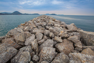 Rocks by sea against sky