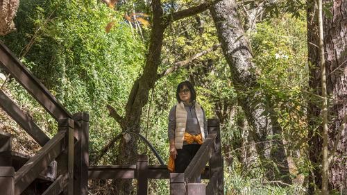 Rear view of woman standing in forest