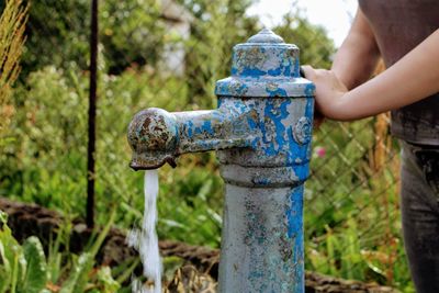 Human hand holding rusty metal