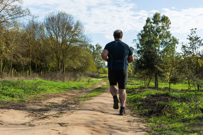 Full length rear view of man standing on footpath