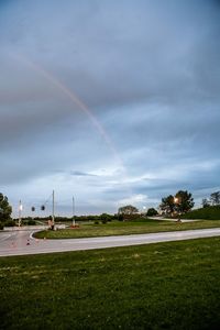 Scenic view of field against rainbow in sky