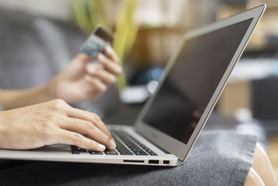 Midsection of man using laptop on table
