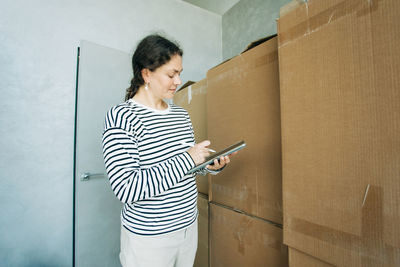 A professional logistician woman registers the cargo in the application.