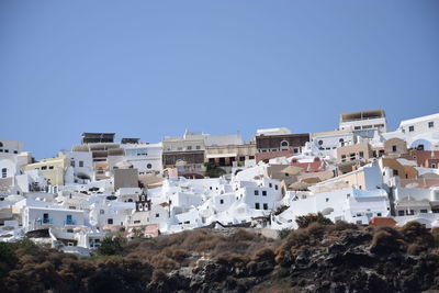 Low angle view of buildings in town against clear blue sky