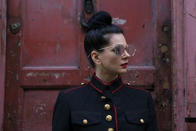 Woman wearing sunglasses against closed door