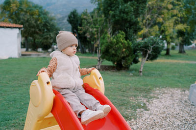 Side view of young woman sitting in park