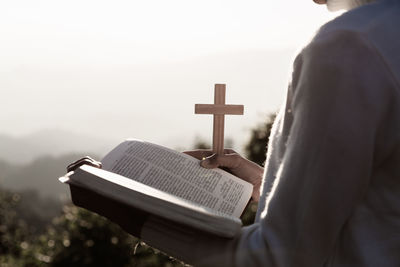 Midsection of man holding book at temple