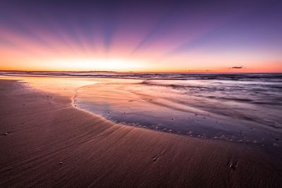 Scenic view of beach against sky during sunset