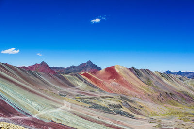 Scenic view of mountains against blue sky