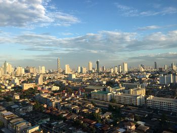 High angle view of city buildings against cloudy sky