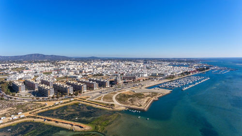 High angle view of buildings in city against clear blue sky