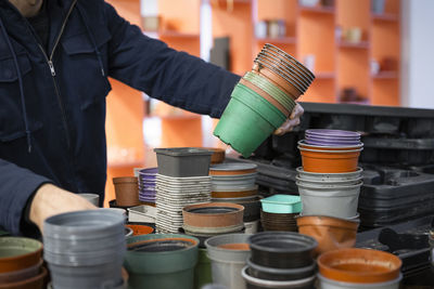 Man choosing reused stacked pots at recycling center