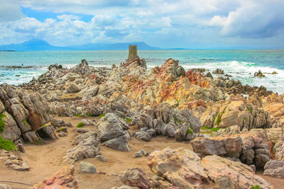 Scenic view of rocks on beach against sky