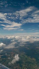 Aerial view of cityscape against cloudy sky