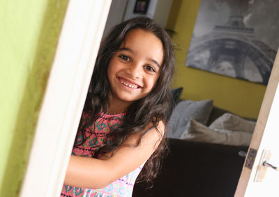 Portrait of smiling girl standing at home