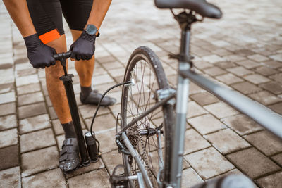 Low section of man filling air in bicycle tire