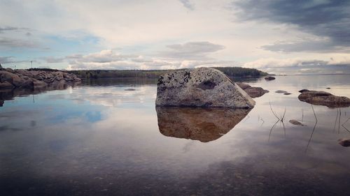 Rocks in sea against sky