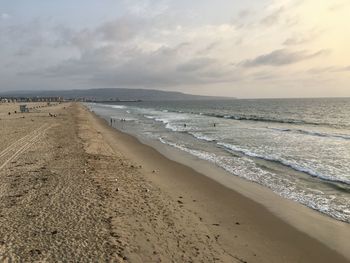 Scenic view of beach against cloudy sky