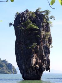 Rock formation by sea against sky