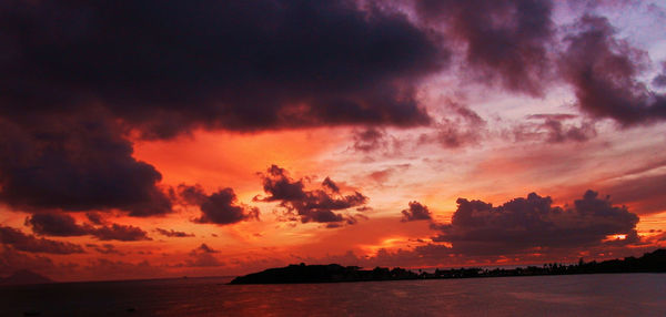 Scenic view of sea against cloudy sky at sunset