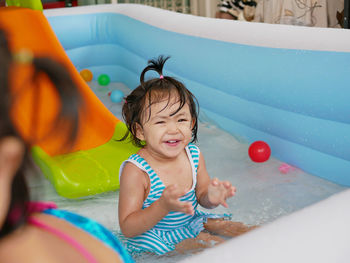 Portrait of cute girl sitting in wading pool