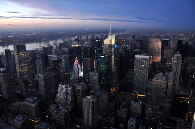 Modern buildings in city against sky at sunset