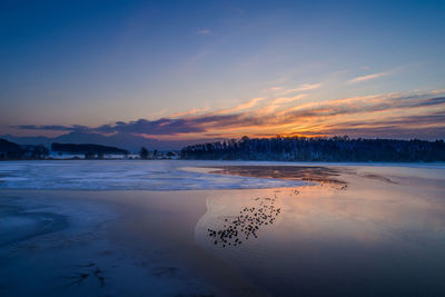 Scenic view of frozen sea against sky at sunset