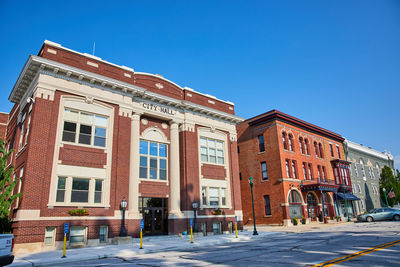 Buildings in city against clear blue sky