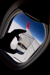 Reflection of person hand holding glass of car