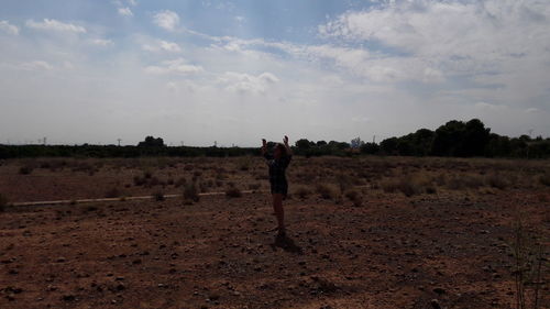 Man standing on field against sky