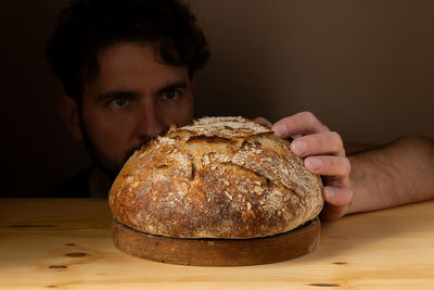 Cropped hand of person holding bread on table