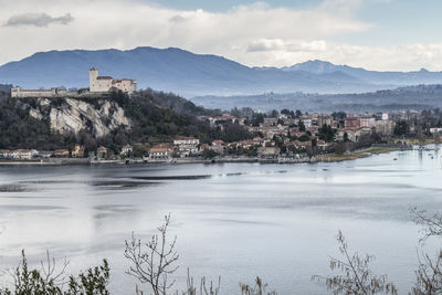 Scenic view of lake by buildings against sky