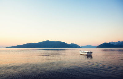 Boat in calm sea at sunset