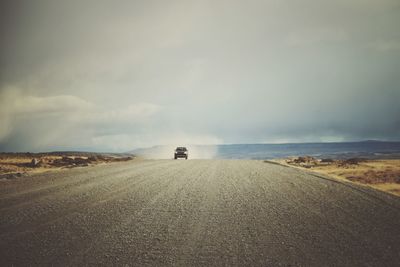 Scenic view of road by sea against sky