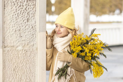 A girl  with a bouquet of mimosa in her hands. spring, international women's day march 8