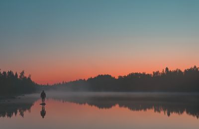 Scenic view of lake against clear sky during sunset