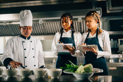 Portrait of smiling female friends standing in cafe