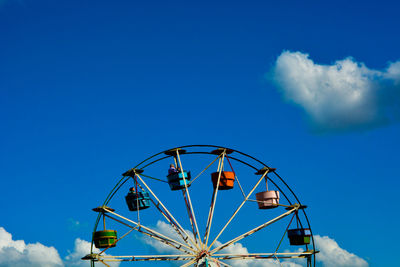 Low angle view of ferris wheel against blue sky