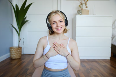 Portrait of young woman standing at home