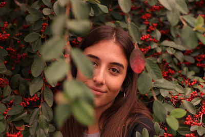 Portrait of young woman with red leaves