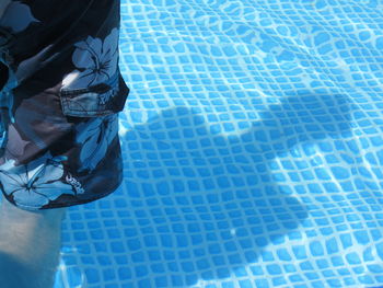 Midsection of man standing in swimming pool